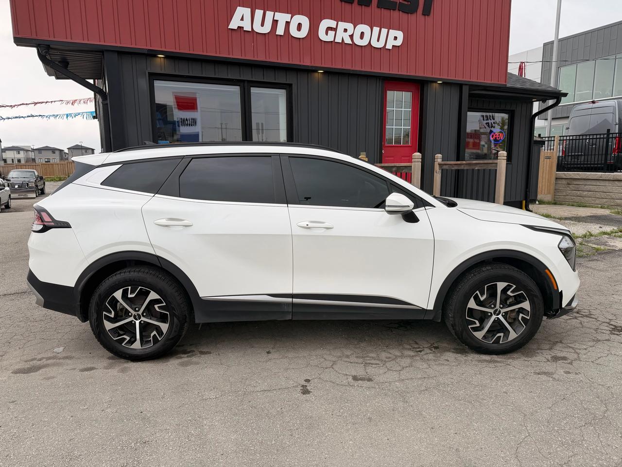 2023 Kia Sportage SUV / Crossover White shown in left side profile view with modern alloy wheels at dealership lot.
