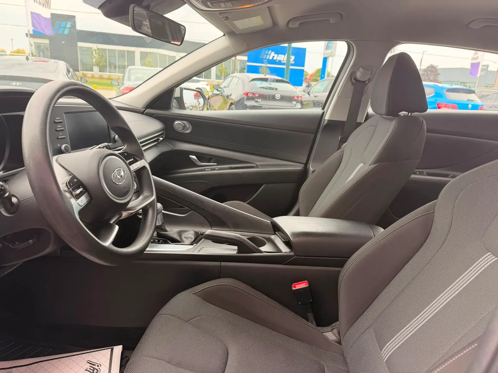 2022 Hyundai Elantra SEL Gray interior cabin view showing steering wheel, dark cloth seats, and dashboard from driver side.