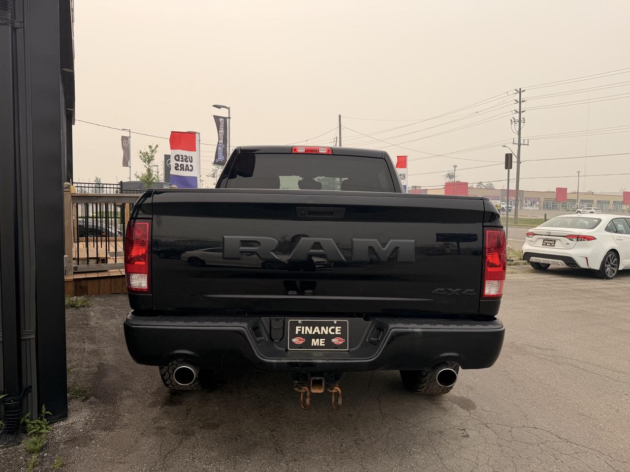 2021 RAM 1500 Classic Pickup Truck Black rear exterior view showing dual exhaust, taillights, and "Finance Me" license plate.