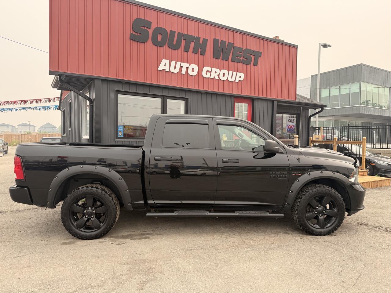 2021 RAM 1500 Classic Pickup Truck Black side profile exterior view with black alloy wheels and fender flares parked at dealership.