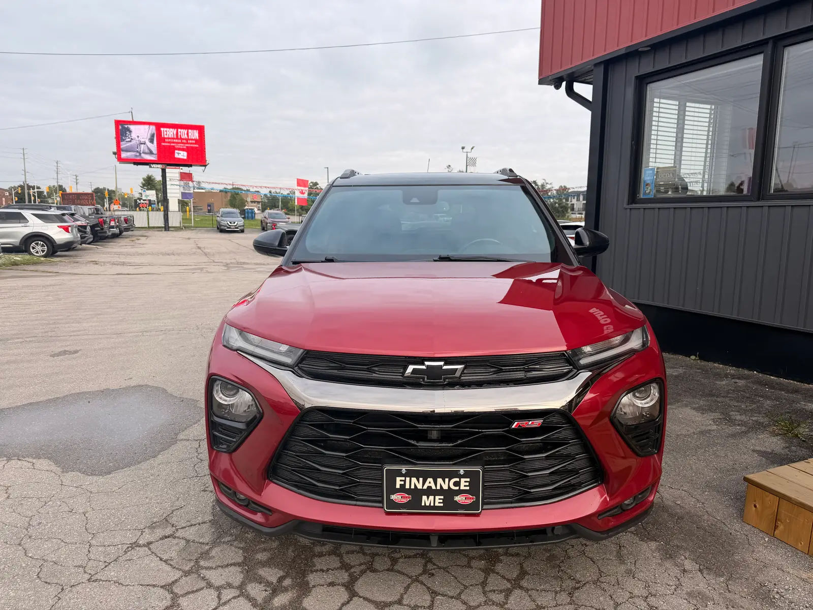 2021 Chevrolet Trailblazer RS Red front exterior view with "Finance Me" dealer plate at dealership lot.
