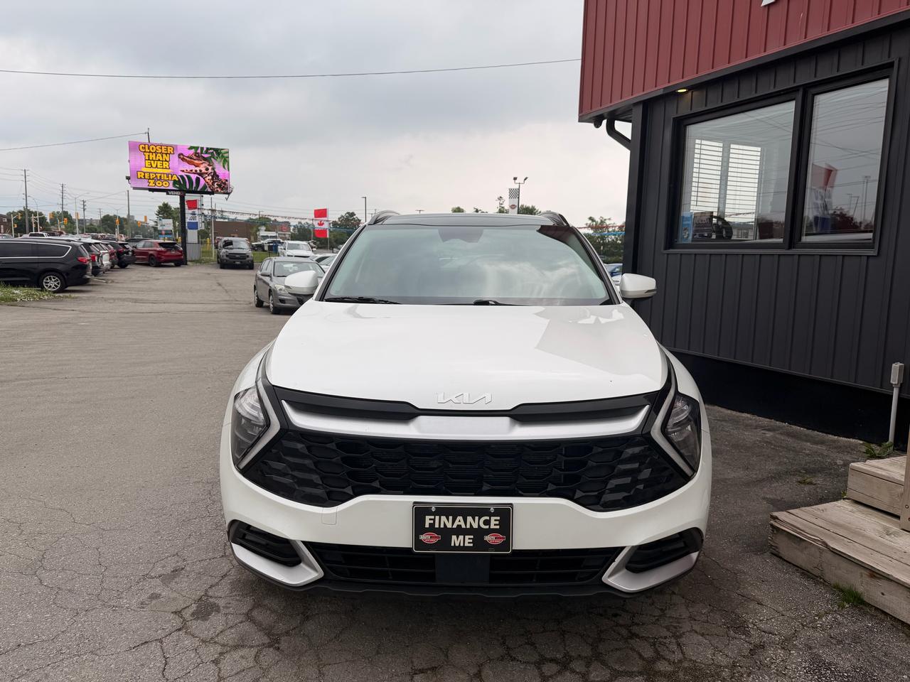 2023 Kia Sportage SUV / Crossover White front exterior view with "Finance Me" license plate at dealership lot.