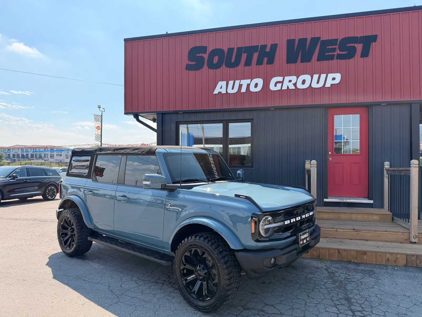 2022 Ford Bronco OUTER BANKS front three-quarter exterior view with custom black alloy wheels parked at dealership.