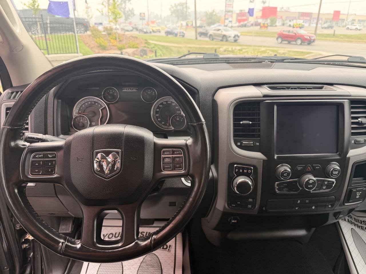 2021 RAM 1500 Classic Pickup Truck Black interior dashboard view with steering wheel, touchscreen infotainment system, and gauges.