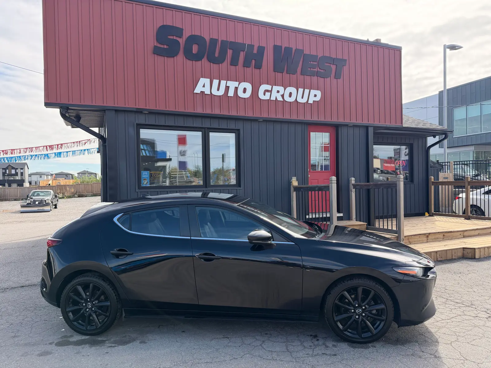 2021 Mazda Mazda3 with Premium Package Black side exterior view showing dark alloy wheels at South West Auto Group dealership.