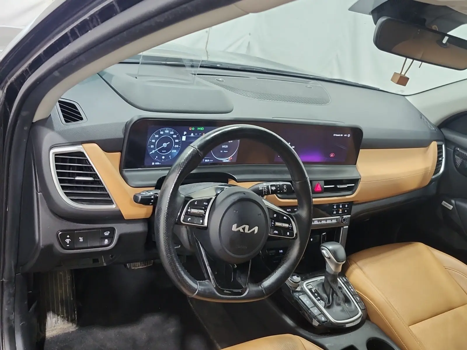 2024 Kia Seltos SX Navy interior dashboard view with tan leather seats, digital instrument cluster, and steering wheel controls.