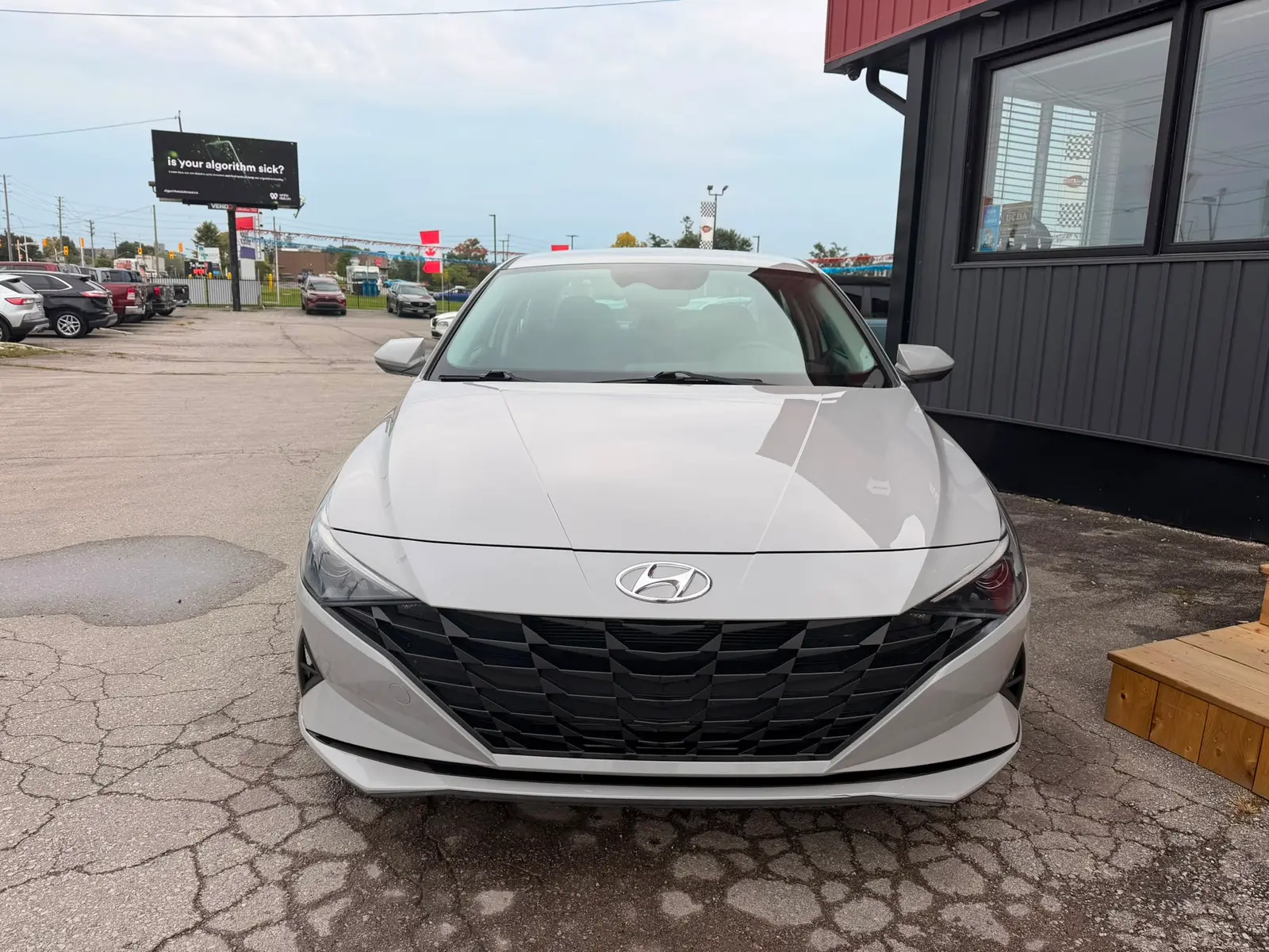 2022 Hyundai Elantra SEL Gray front exterior view with diamond mesh grille and dark headlights in dealership lot.