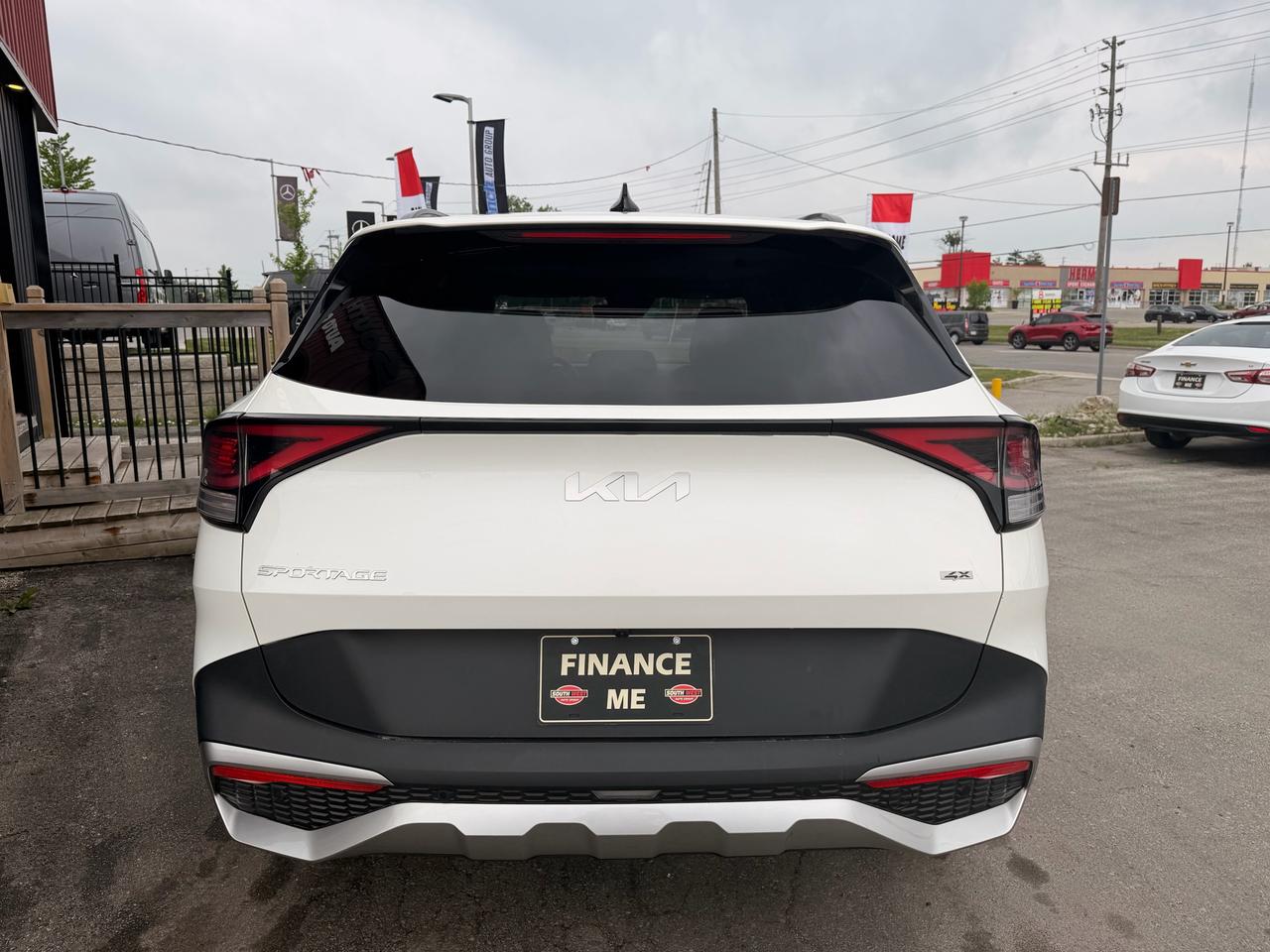2023 Kia Sportage SUV Crossover White rear exterior view with FINANCE ME license plate and red LED taillights.