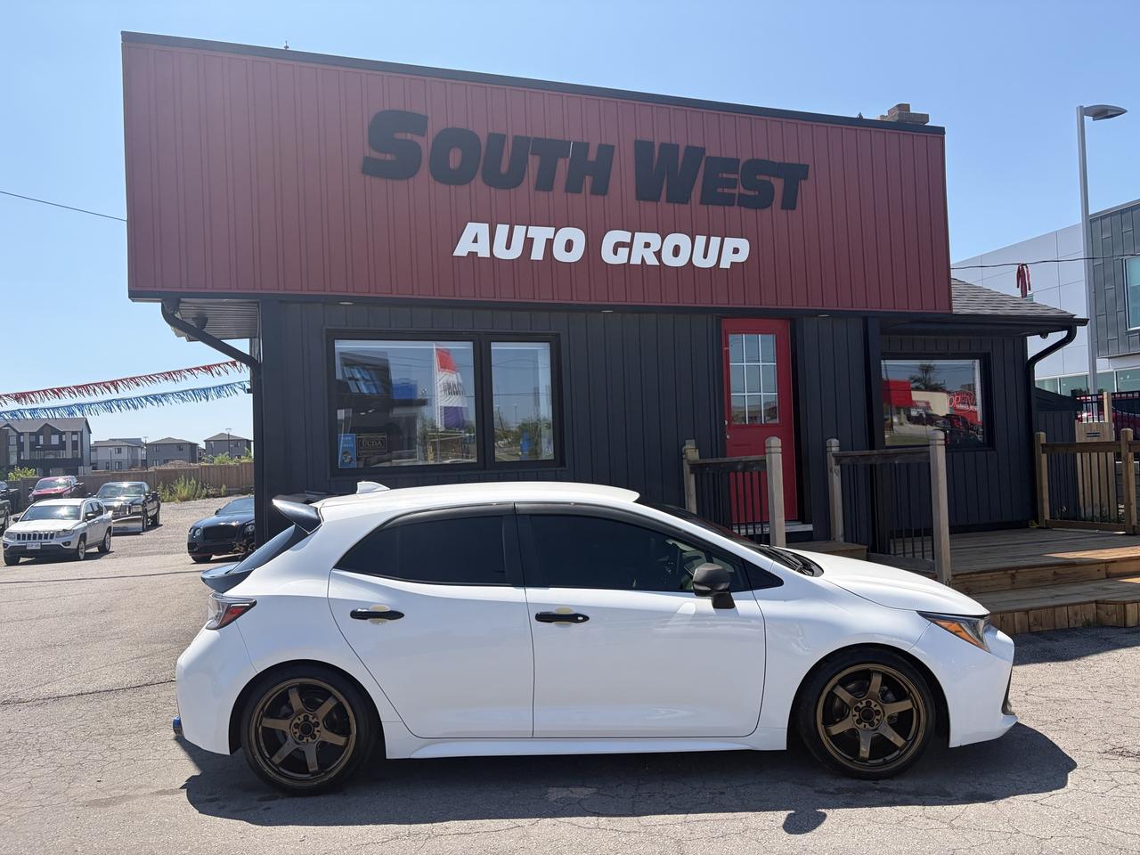 2020 Toyota Corolla Sedan White shown in left side profile view with bronze alloy wheels at South West Auto Group dealership.