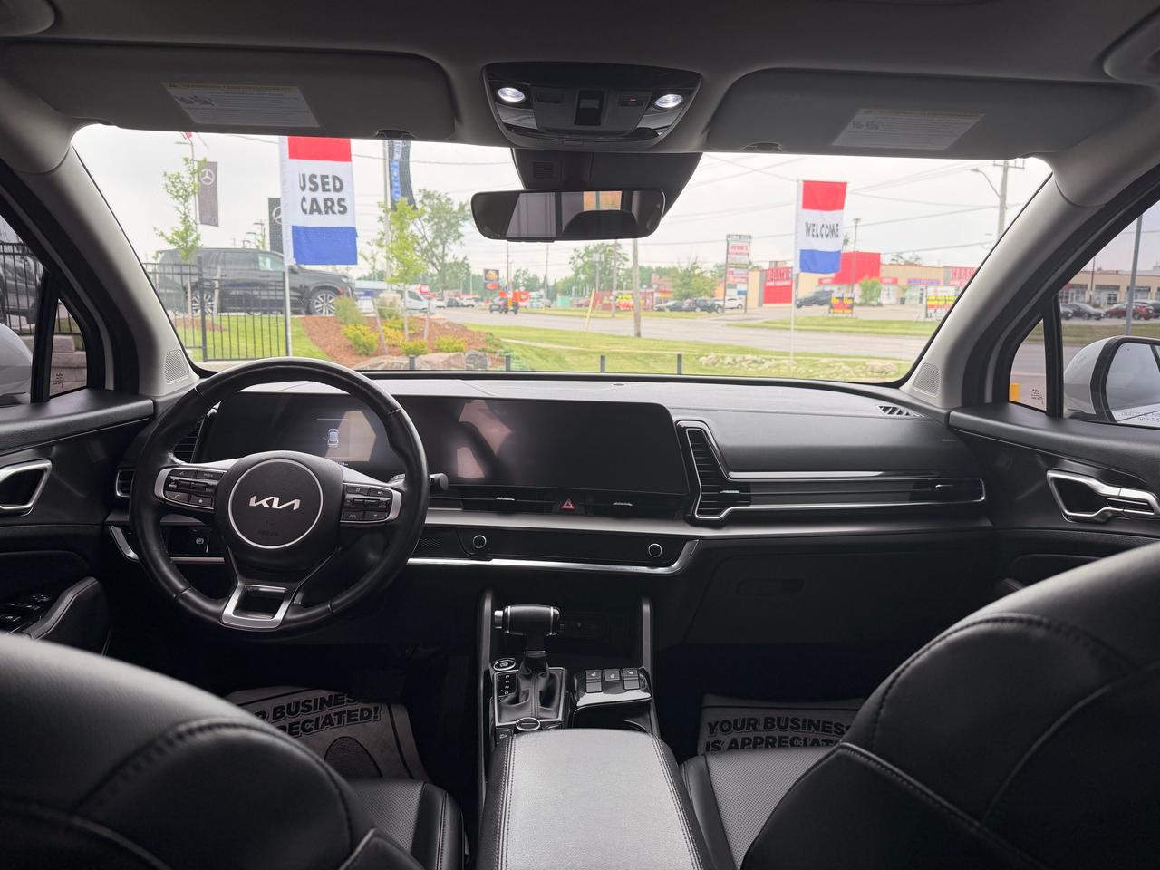 2023 Kia Sportage SUV / Crossover White interior dashboard view with black leather seats and modern infotainment display.