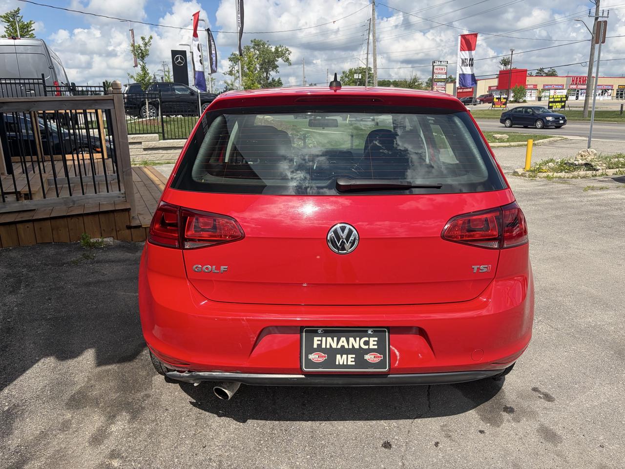2017 Volkswagen Golf Sedan Red rear exterior view with "Finance Me" license plate visible at dealership lot.