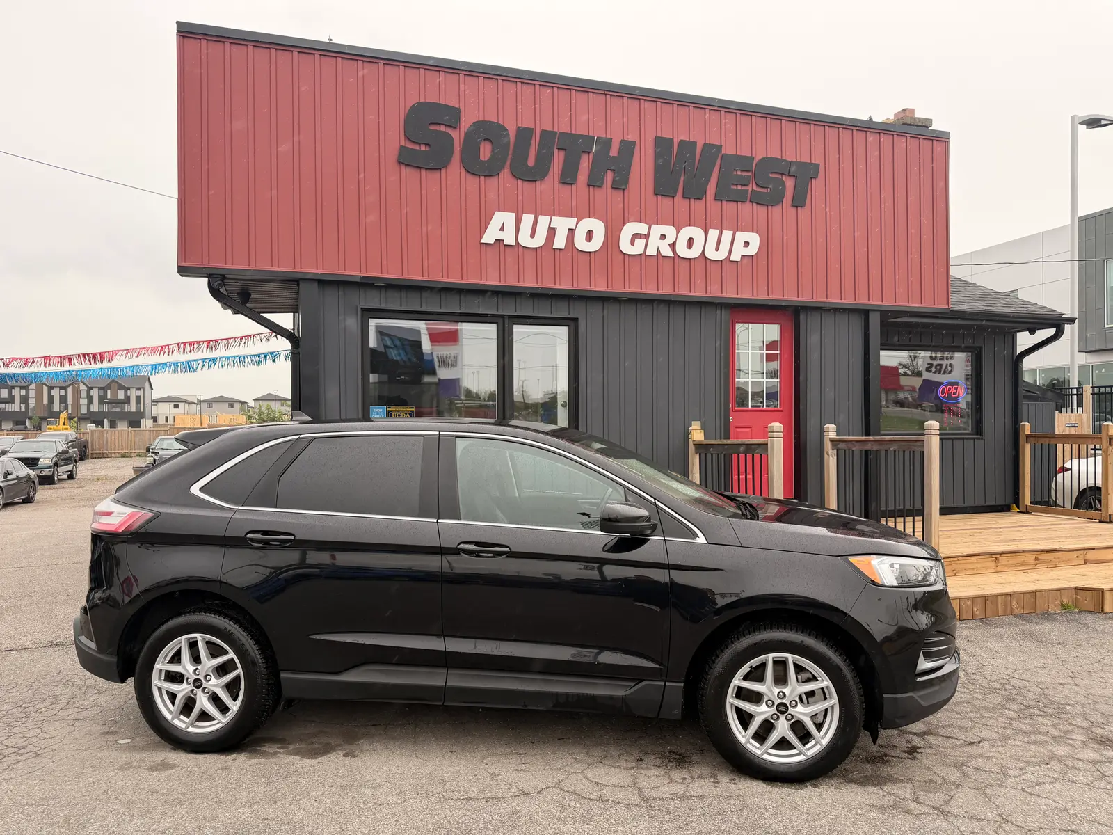 2023 Ford Edge SEL Black driver side exterior view with silver alloy wheels parked in front of South West Auto Group dealership.