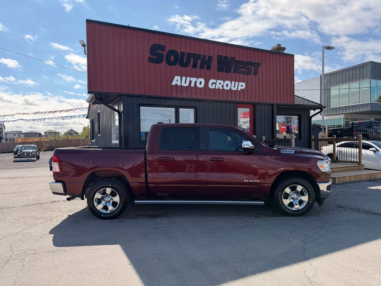 2021 Ram 1500 Big Horn, Lonestar Red shown in side profile exterior view with chrome wheels at South West Auto Group dealership.