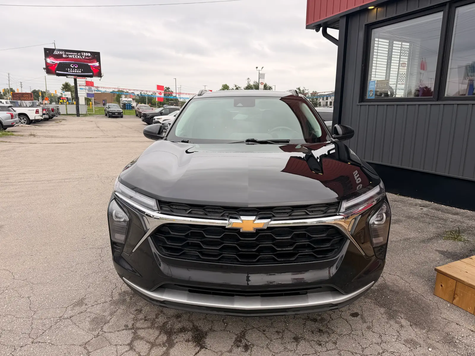 2024 Chevrolet Trax 1LT Black front three-quarter exterior view at dealership lot with LED headlights and chrome accents visible.