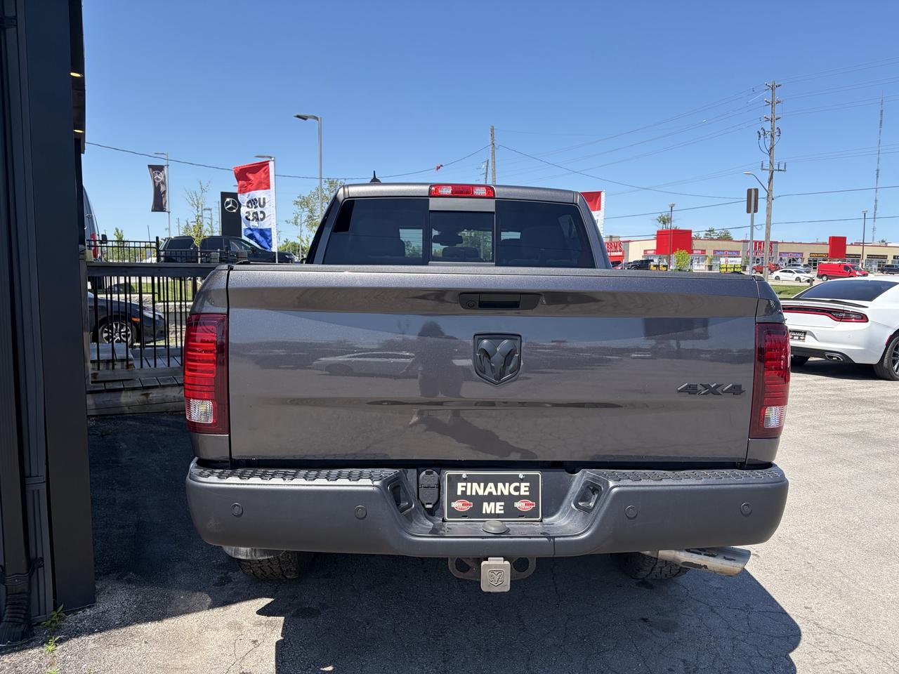 2021 RAM 1500 Classic Pickup Truck rear exterior view showing gray bed with RAM badging and 4X4 designation under bright daylight at dealership.