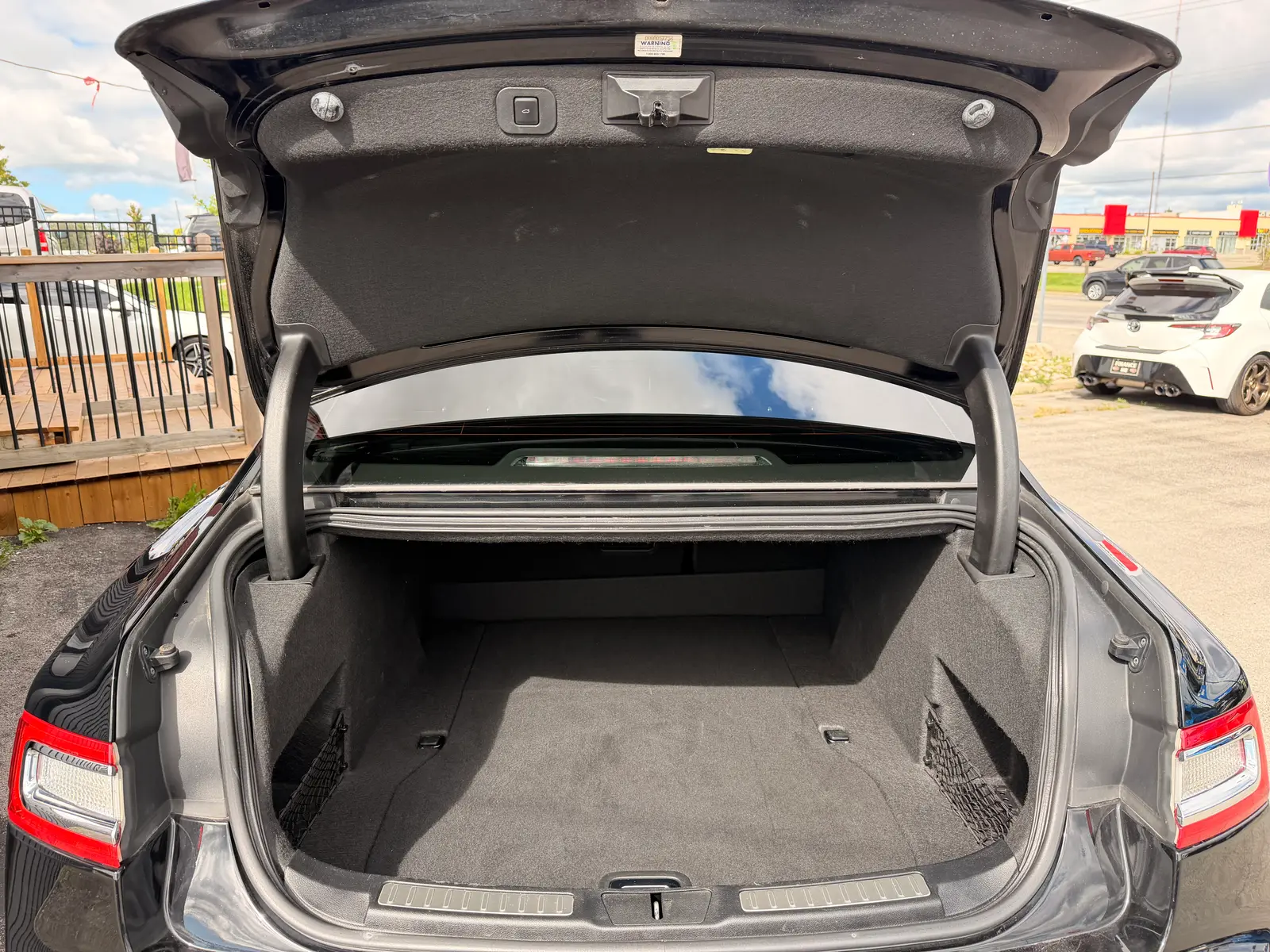 2017 Lincoln Continental Reserve Black rear cargo area with trunk open, showing spacious gray carpeted trunk space and rear seat configuration.