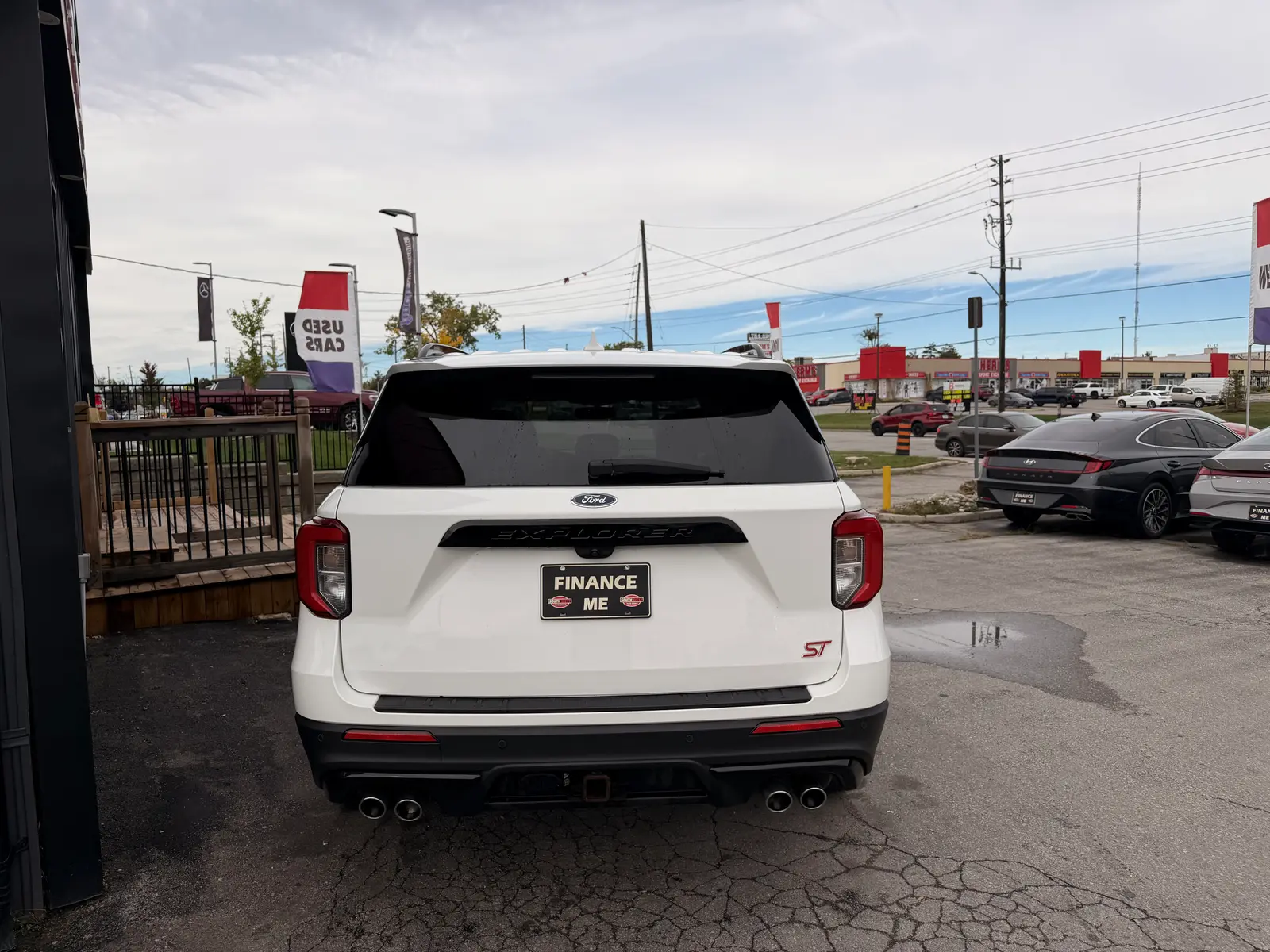 2020 Ford Explorer ST White rear exterior view showing dual exhaust, red taillights, and Finance Me dealership plate at automotive lot.