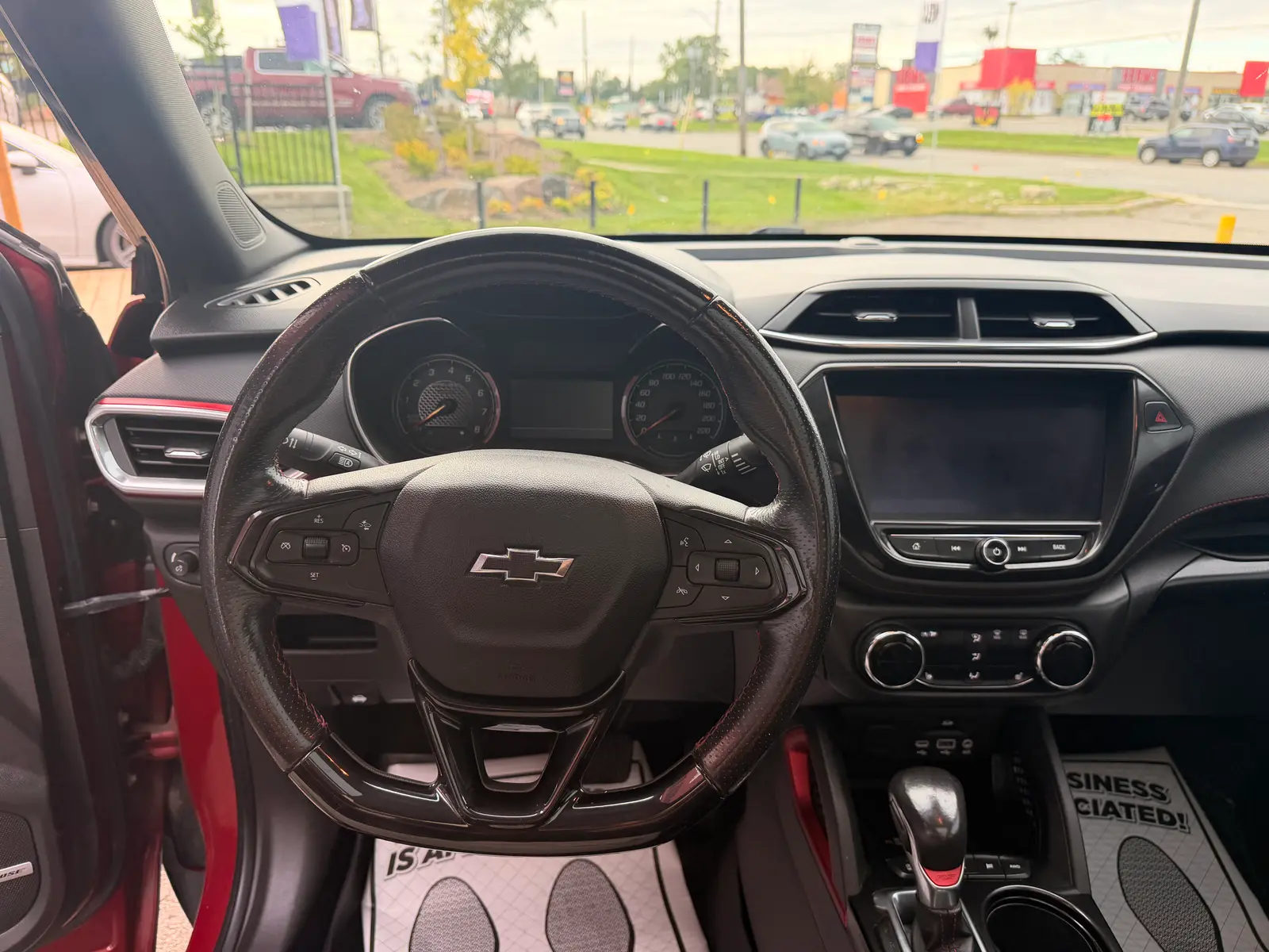 2021 Chevrolet Trailblazer RS Red interior dashboard view with leather steering wheel, touchscreen infotainment, and dual-zone climate controls.