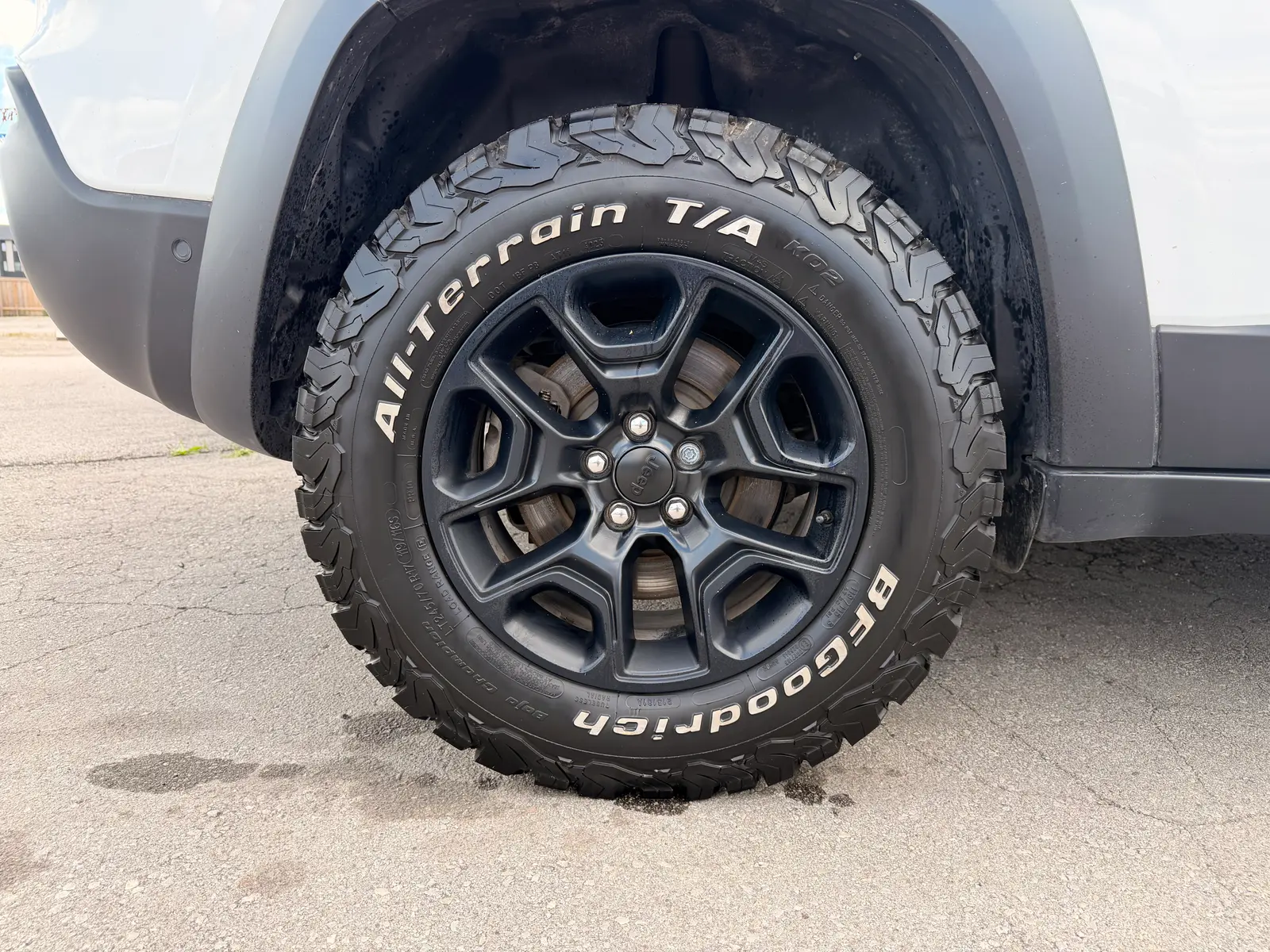 2021 Jeep Cherokee Trailhawk White close-up of BFGoodrich all-terrain tire on black alloy wheel with brake calipers visible.
