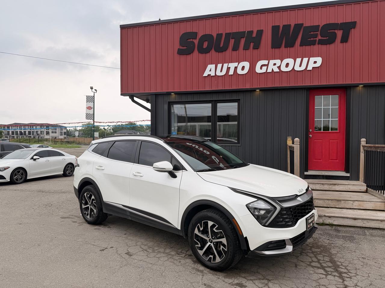 2023 Kia Sportage SUV / Crossover White front three-quarter exterior view at dealership with distinctive alloy wheels.