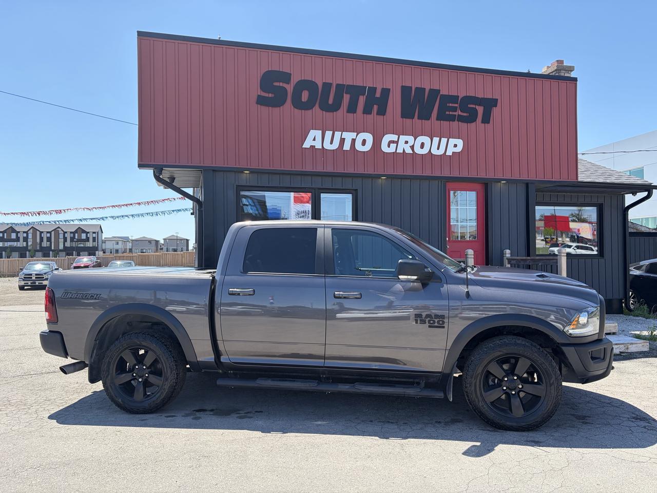 2021 RAM 1500 Classic Pickup Truck side exterior view with black alloy wheels parked at South West Auto Group dealership.