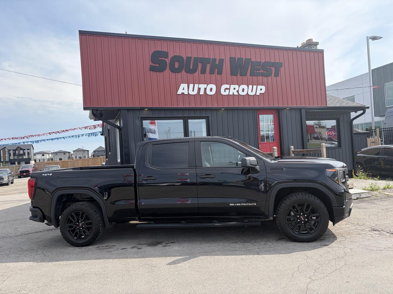 2023 GMC Sierra 1500 Pickup Truck Black side exterior view with black alloy wheels parked at dealership.