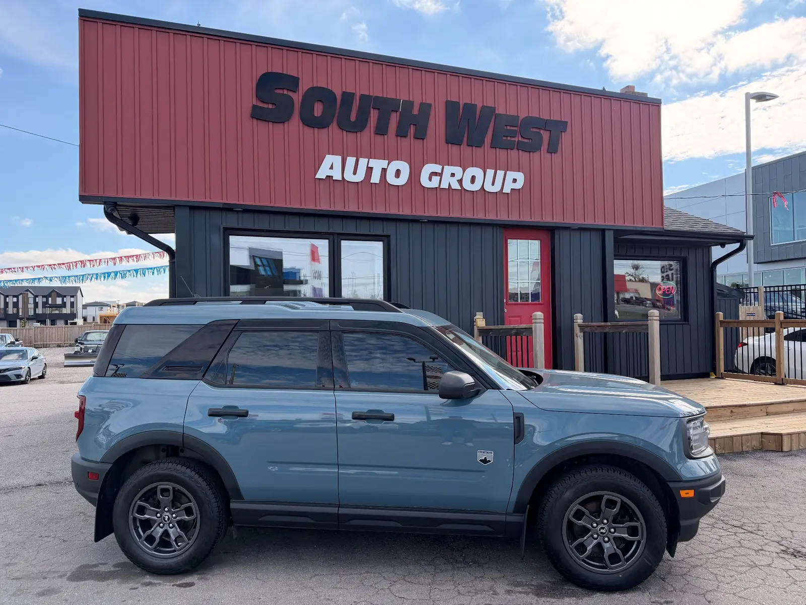2021 Ford Bronco Sport Big Bend Blue exterior side view with alloy wheels parked outside South West Auto Group dealership.