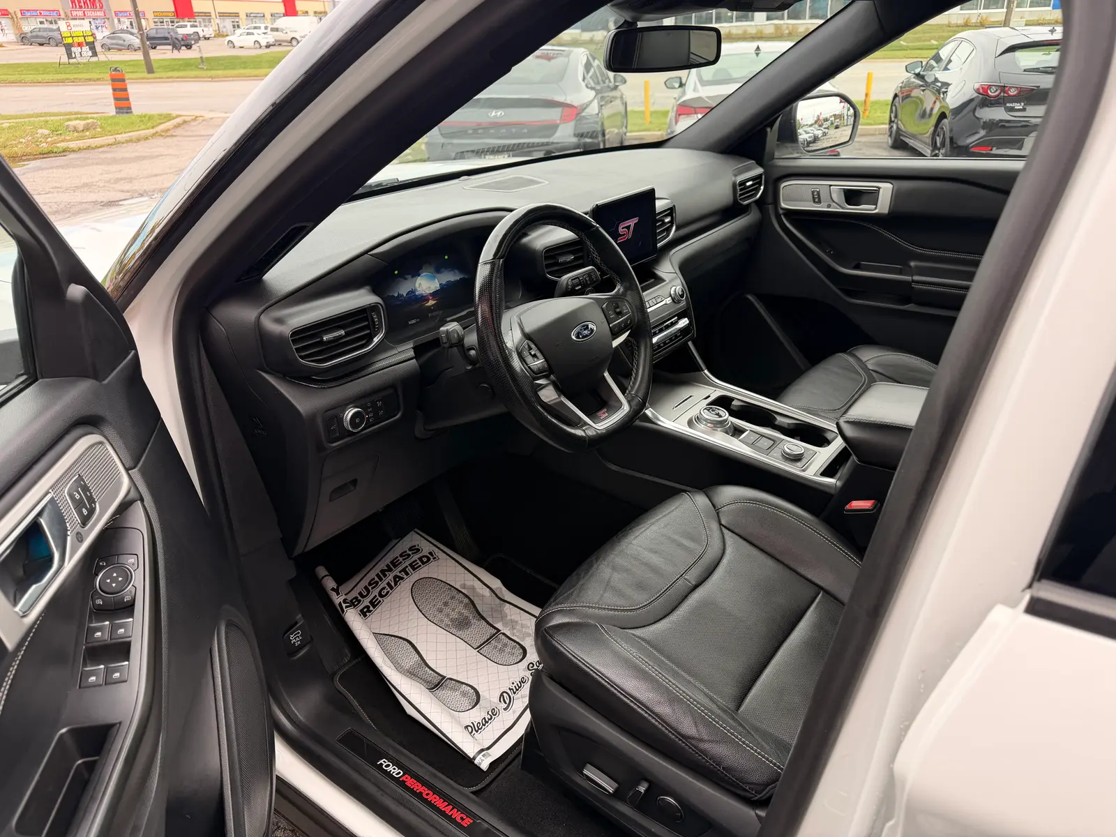 2020 Ford Explorer ST White interior driver side view with black leather seats, touchscreen display, and ST badging visible.