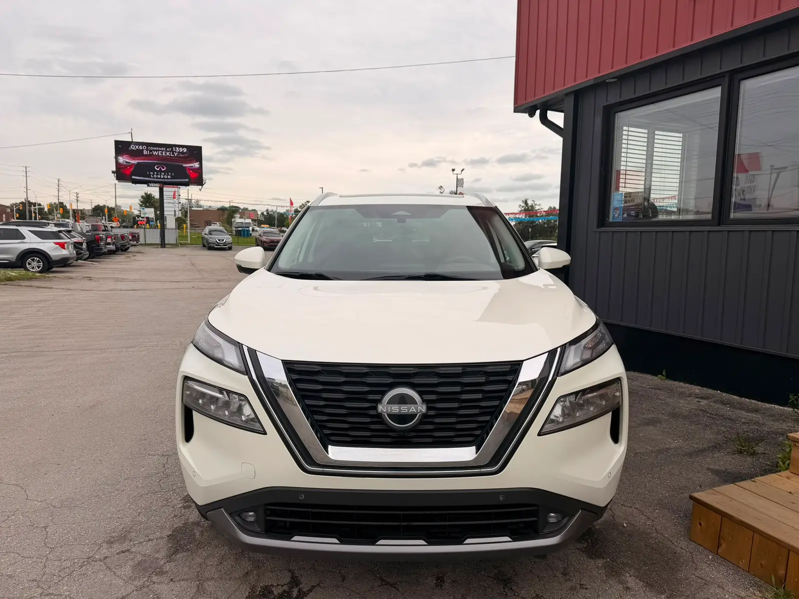 2022 Nissan Rogue SL White front exterior view parked at dealership with black grille and pearl white finish visible.